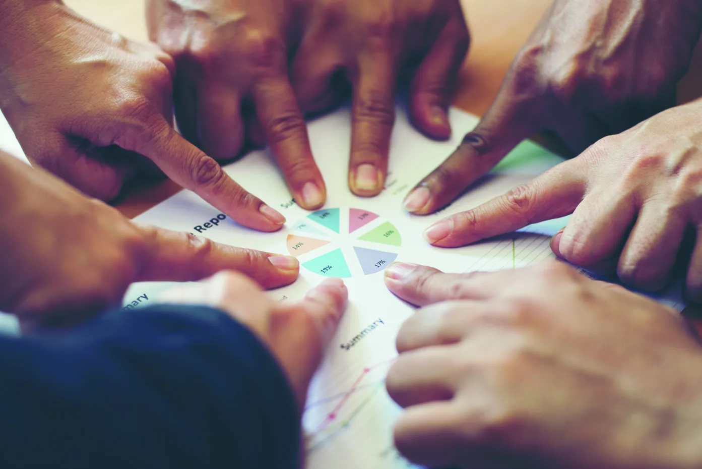 Hands meeting over a wheel of core values, representing the Kites approach to service